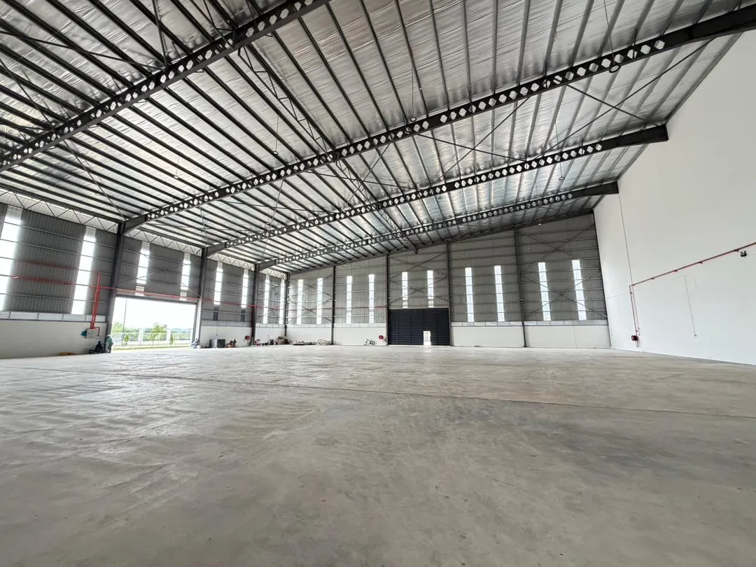 Clear-span factory interior with roller shutter door open to the yard